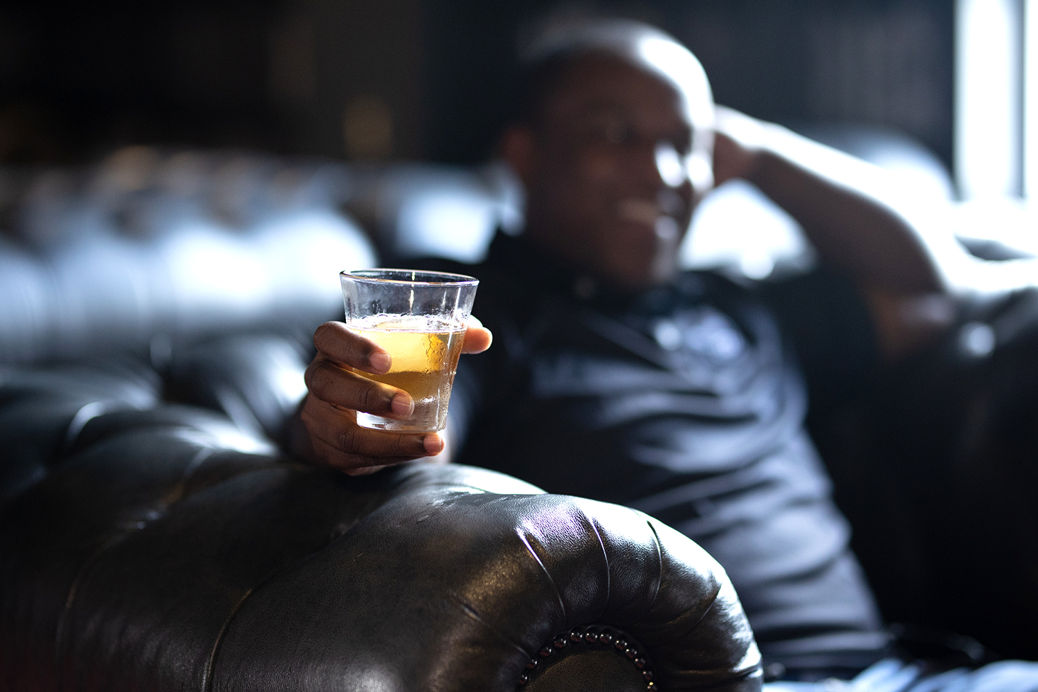Man sitting holding a glass of whiskey