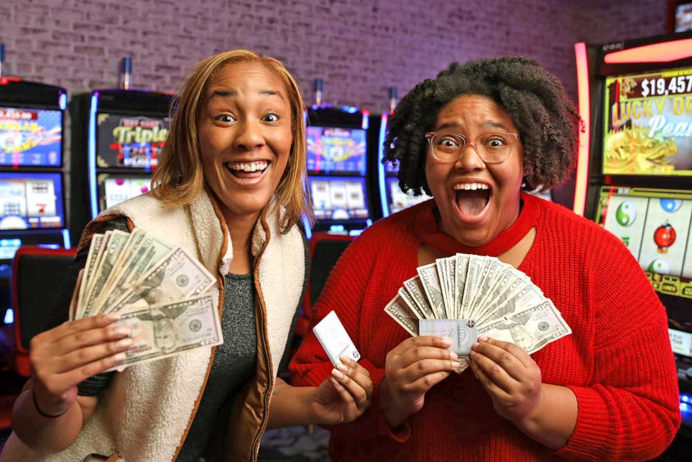 Two women holding money on gaming floor