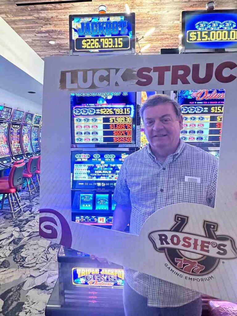 Recent jackpot winner Ernie posing for a picture in a winners frame that says Luck Struck.