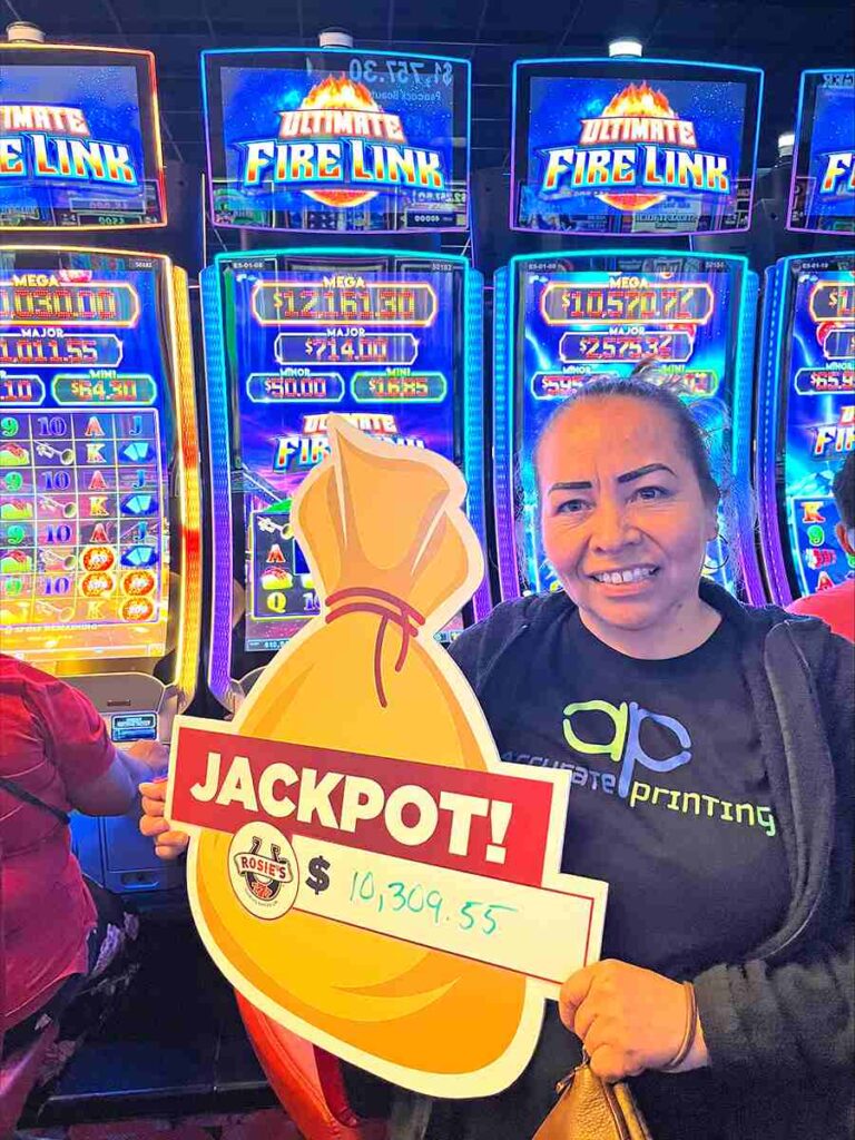 Recent lucky jackpot winner holding a sign that says JACKPOT!