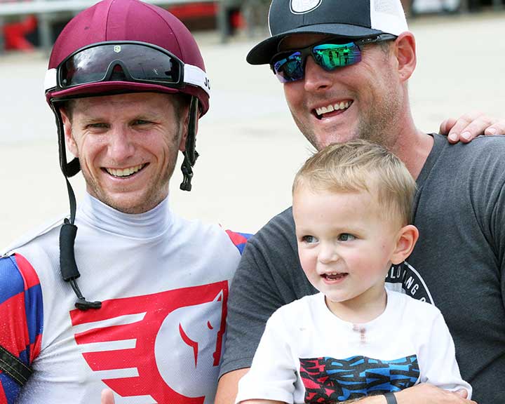 Dad and kid with jockey during races